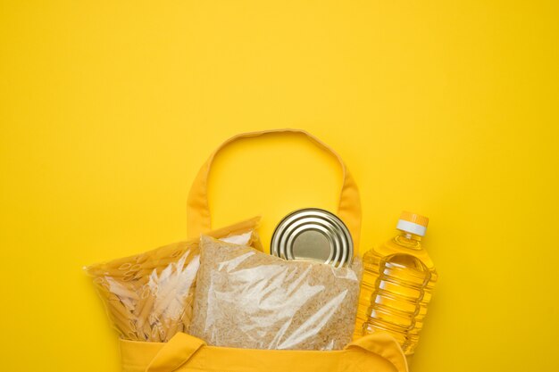 Bolsa ecológica textil amarilla con comestibles. Compra de productos, entrega de comida