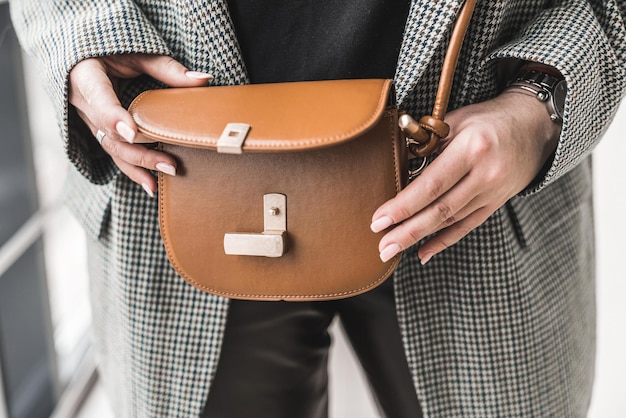 Bolsa em miniatura de couro delicado de qualidade extremamente estilosa nas mãos de uma menina. Conceito de estilo