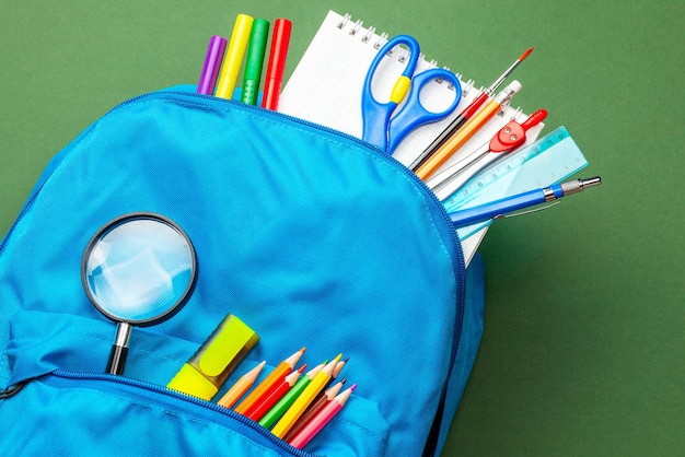 Bolsa escolar mochila con suministros para la escuela en fondo verde