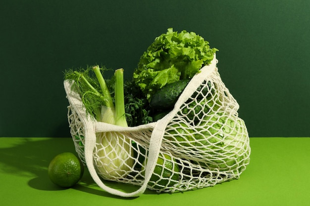 Bolsa de hilo con verduras y frutas sobre fondo bicolor