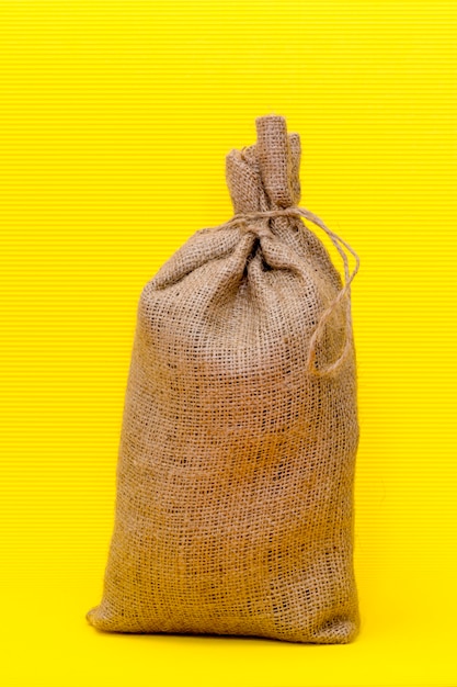 Foto bolsa llena anudada sobre un fondo amarillo