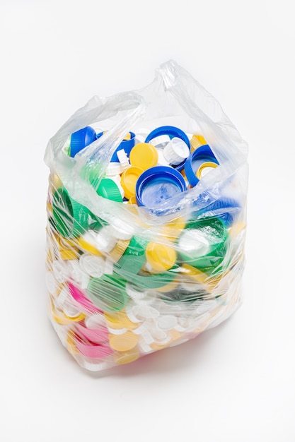 Bolsa llena de tapones de plástico listos para ser reciclados. Concepto de reciclaje. Copia espacio