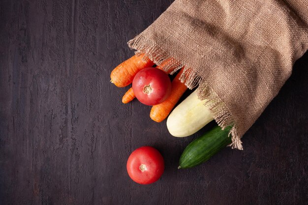 bolsa de lona con verduras sobre fondo marrón