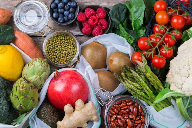 Bolsa de malla textil con productos, frutas y verduras. Cero desperdicio, ecológico, reciclado sin plástico, reutilizable, concepto de compra de comestibles sostenible. Fondo plano laico