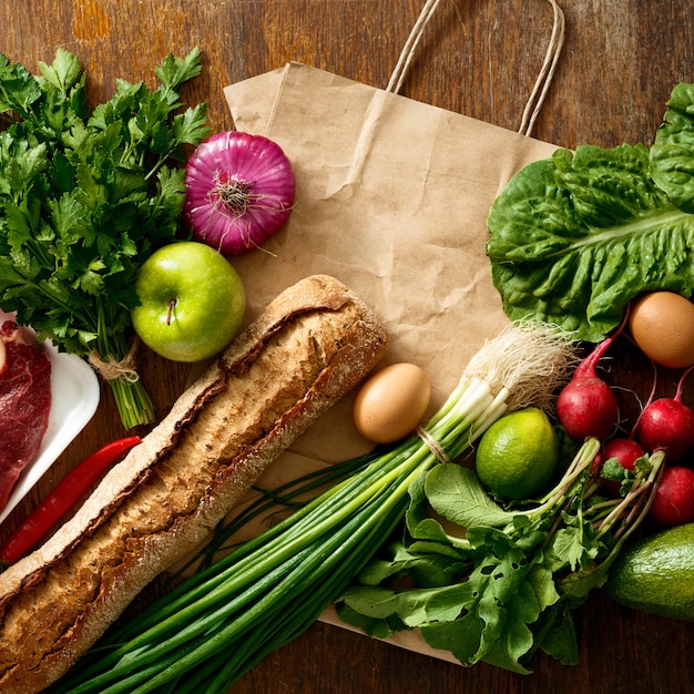 Bolsa de papel diferentes alimentos saludables mesa de madera