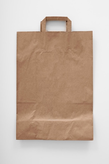 Bolsa de papel doblada con asa sobre un fondo blanco Diseño para publicidad