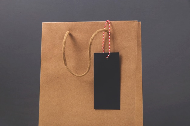 Bolsa de papel Kraft con etiqueta de compra de viernes negro en superficie oscura brillante.