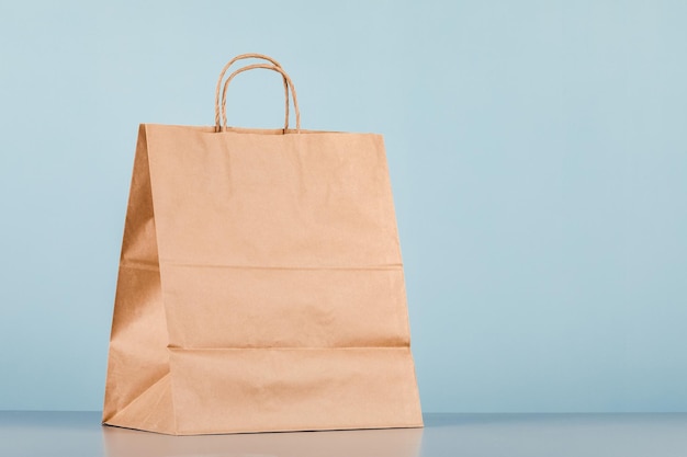 Bolsa de papel marrón con asas, bolsa de compras vacía con área para su logotipo o diseño, concepto de entrega de alimentos.