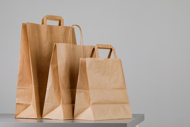 Bolsa de papel marrón con asas, bolsa de compras vacía con área para su logotipo o diseño, concepto de entrega de alimentos.