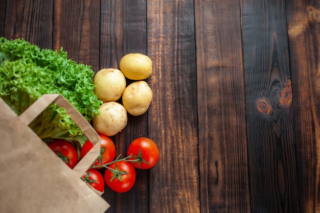 Bolsa de papel en un marrón de madera, verduras de la tienda.