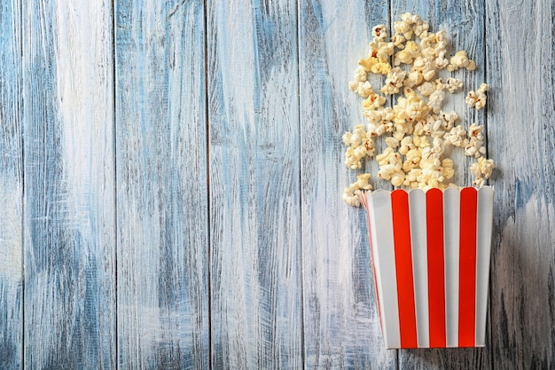 Bolsa de papel con palomitas de maíz en mesa de madera