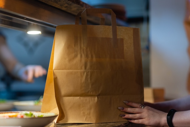 Bolsa de papel de postre esperando al cliente en el mostrador de la moderna cafetería cafetería, entrega de alimentos, cafetería restaurante, comida para llevar.