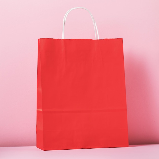 Bolsa de papel rectangular en blanco en rojo sobre un fondo rosa de cerca