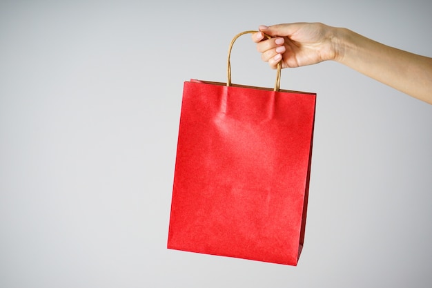 Bolsa de papel roja en una mano femenina