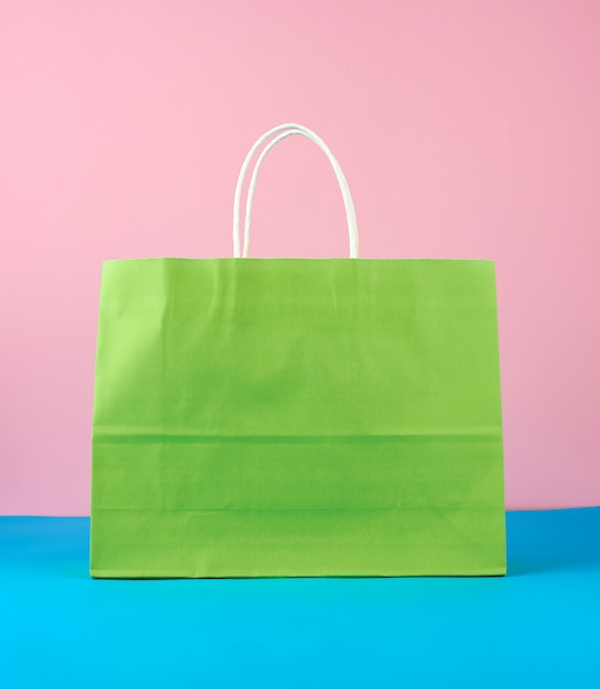 Bolsa de papel verde vacía con asas blancas para compras y regalos