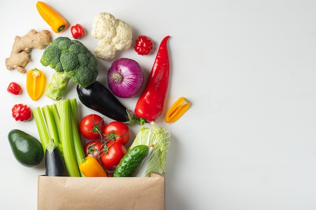 Bolsa de papel con las verduras en el fondo blanco.