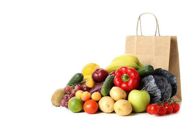 Bolsa de papel, verduras y frutas aisladas sobre fondo blanco.