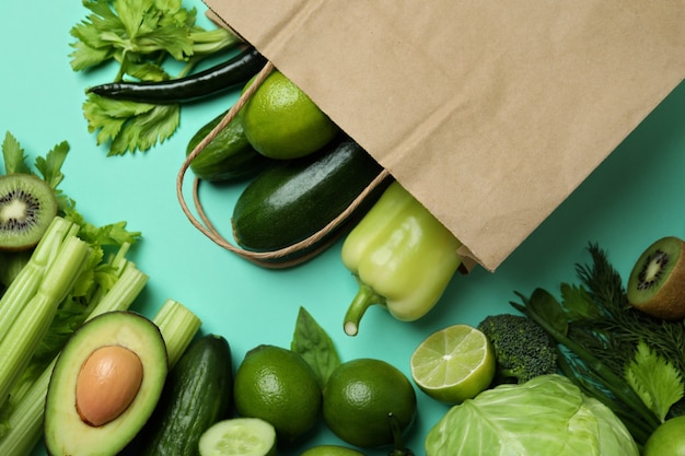 Bolsa de papel con verduras verdes sobre menta