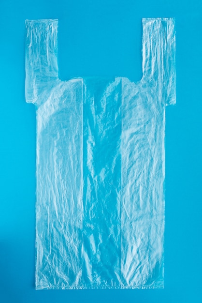 Bolsa de plástico para caja de pizza sobre superficie azul. Entrega de comida. concepto de innovación