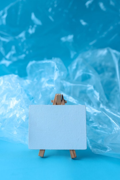 Bolsa de plástico con tablero en blanco vacío para texto sobre fondo azul. Concepto libre de plástico.