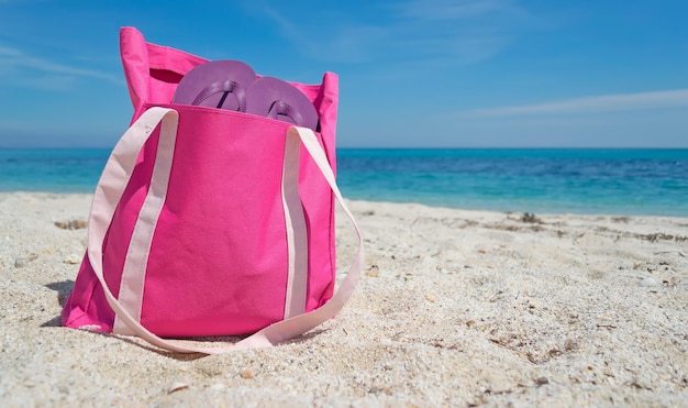 Bolsa de playa rosa en la arena