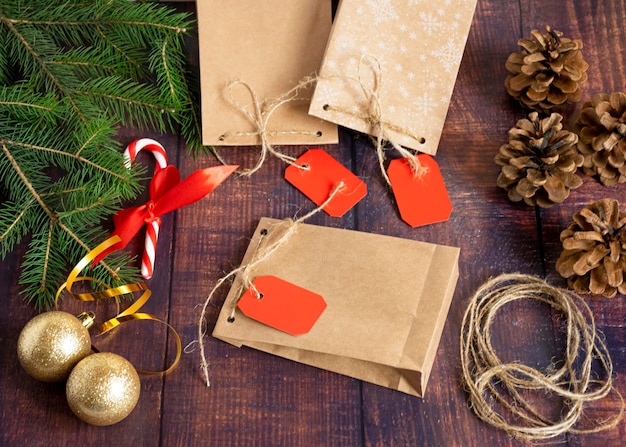 Bolsa de regalo hecha de papel kraft hecho a mano sobre un fondo de madera en un estilo navideño decorado con conos de bolas de árbol de Navidad una bola de ramas de abeto de cuerda Navidad Año Nuevo vacaciones de invierno