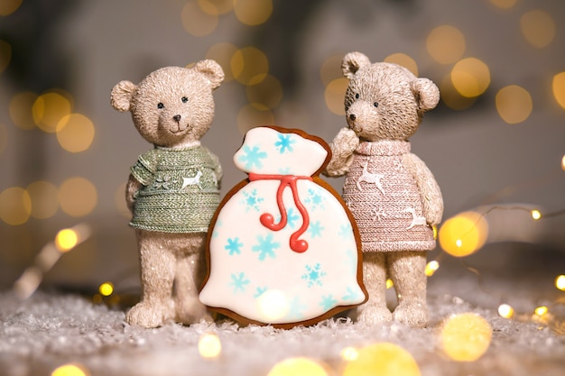 Bolsa de regalos de pan de jengibre y dos osos decorativos en una acogedora decoración cálida con luces de guirnaldas