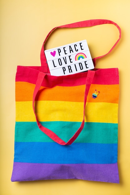 Bolsa reutilizable de arco iris de texto de orgullo de amor de paz sobre fondo amarillo