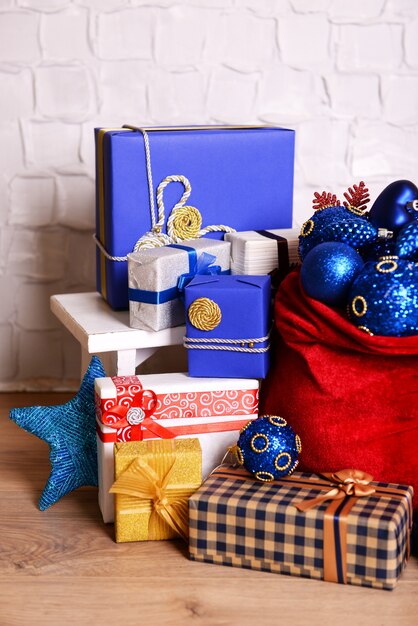 Bolsa roja con juguetes y regalos navideños en la habitación.