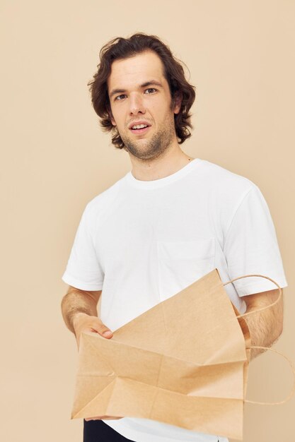 Bolsa de supermercado de papel de hombre alegre posando fondo aislado