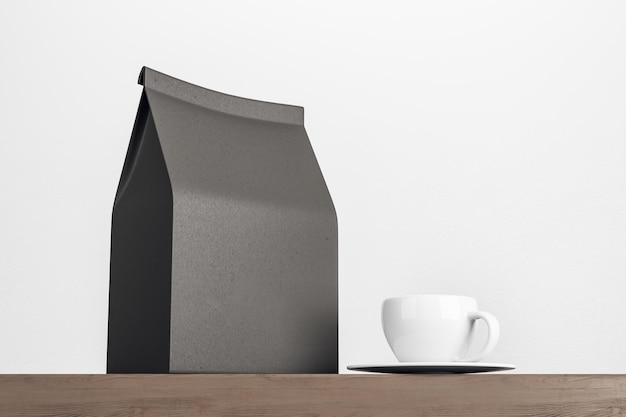 Bolsa de té de papel negro en blanco con taza de café con leche en la mesa de madera sobre fondo blanco Mockup