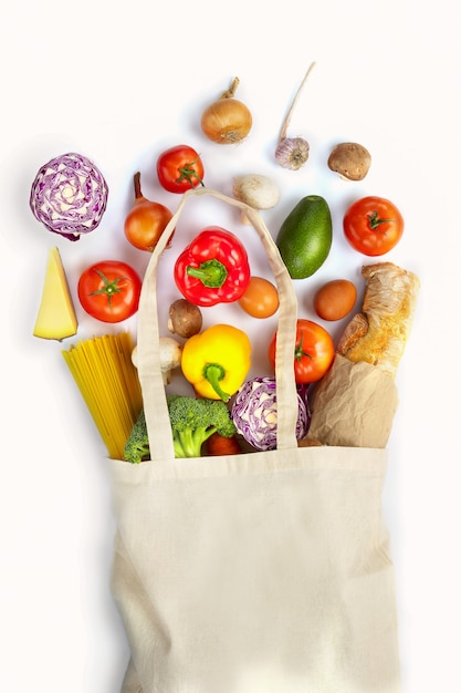 Bolsa de tela con verduras sobre fondo blanco.