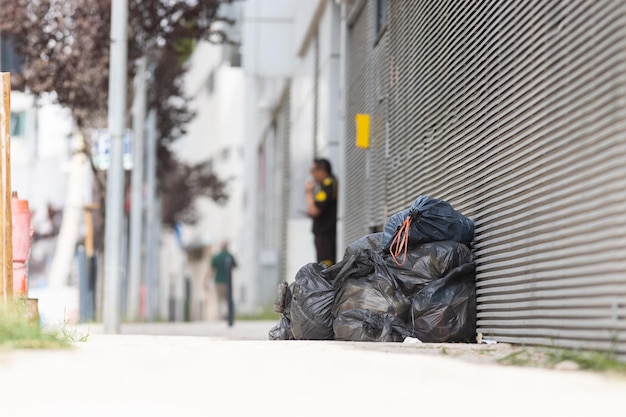 Bolsas y basura al lado de una pared de la calle basura en la calle