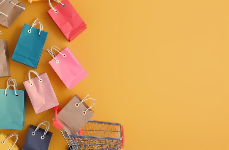 Foto bolsas y carrito de compras sobre un fondo amarillo