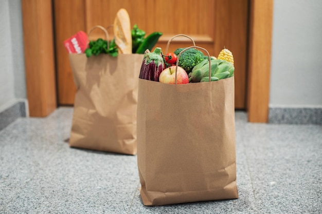 Las bolsas de compra de alimentos se colocan en la puerta de la casa o apartamento. Entrega de verduras y frutas durante cuarentena y autoaislamiento.