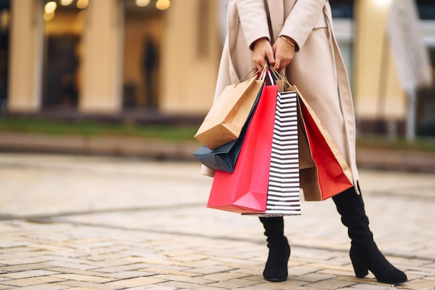 Bolsas de compras en las manos. Mano de mujer joven con bolsas multicolores con compras.