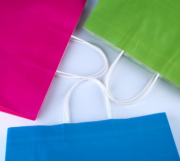 Bolsas de compras de papel rosa, azul y verde con asa