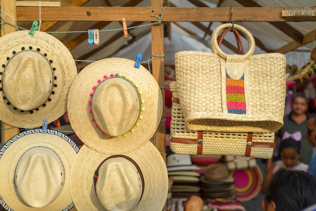 Bolsas e chapéus feitos com fibra de palmeira trançada em um mercado de artesanato de rua mexicano