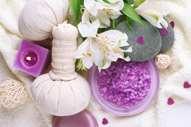 Bolsas de masaje con tratamiento de spa y flores sobre fondo de mesa de madera