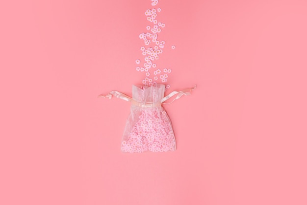 Bolsas de organza en textura de fondo rosa con hermosas flores que salen, margaritas blancas, primavera, día de la madre, amor, concepto mínimo de vacaciones.