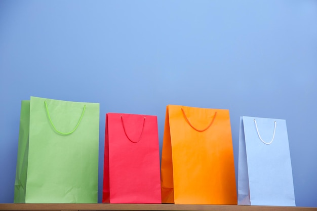 Bolsas de papel de colores sobre fondo azul.