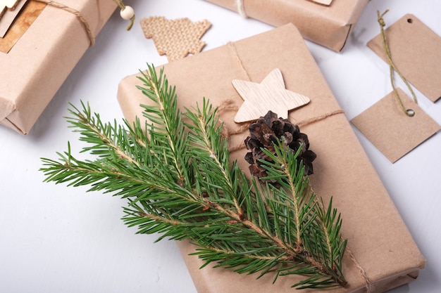 Bolsas de papel ecológico decoradas con cintas y una rama de abeto seca, cintas y piñas