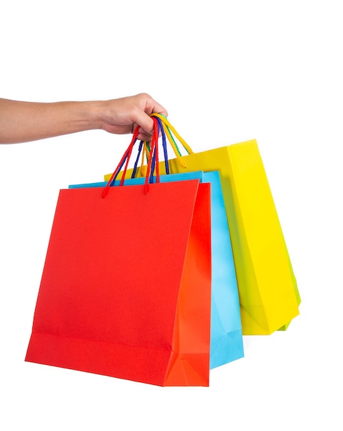 Foto bolsas de papel multicolores con la mano aisladas en el concepto de compras blancas