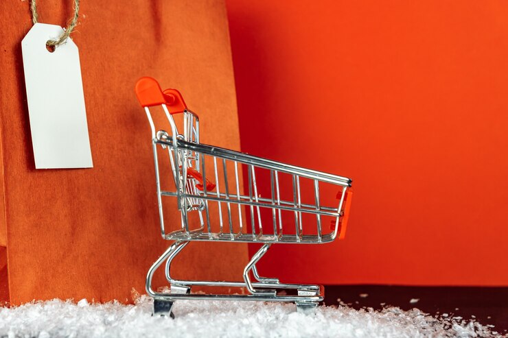 Foto bolsas de papel rojo y carrito de compras de juguete pequeño en la habitación roja