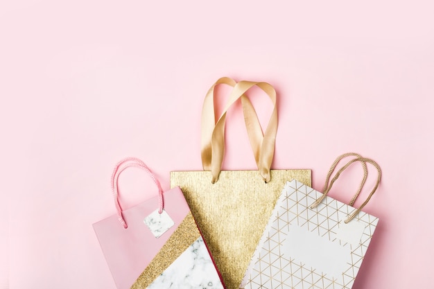 Bolsas de papel sobre fondo rosa. Concepto de venta de vacaciones en colores pastel.