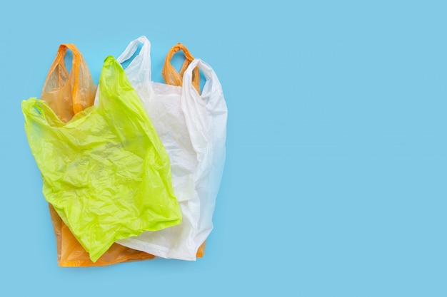 Bolsas de plástico de colores sobre fondo azul.