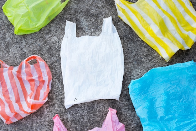 Bolsas de plástico de colores sobre fondo de piso de cemento