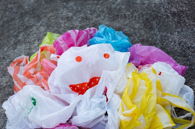 Bolsas de plástico coloridas en piso de cemento