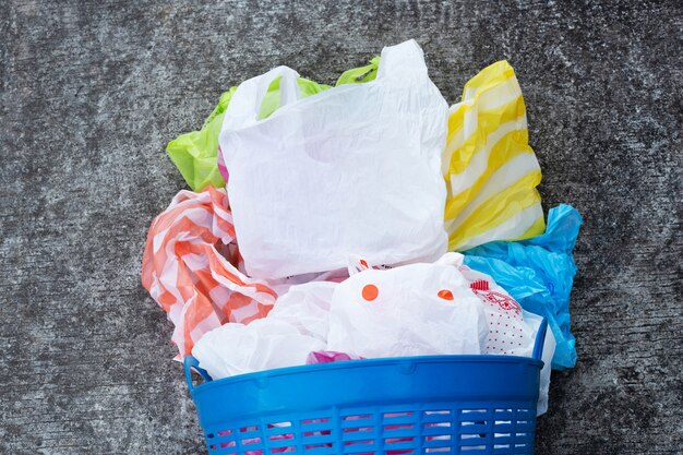 Bolsas de plástico coloridas en piso de cemento