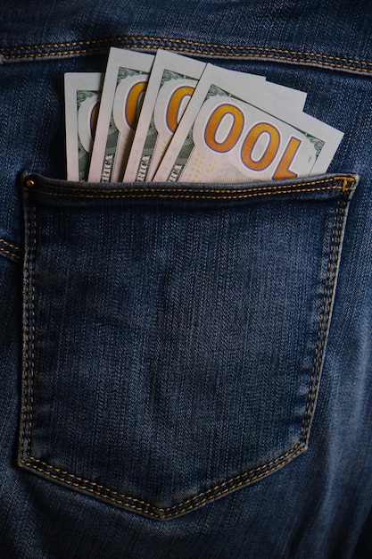 Bolsillo de blue jeans con billetes de cien dólares